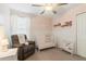 This delightful Bedroom offers soft pink walls, chair, crib and ample natural light at 6180 Spring Crayfish Ave, New Port Richey, FL 34653