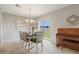A dining room with an elegant chandelier, a piano, and sliding glass door leading to the outdoors at 6180 Spring Crayfish Ave, New Port Richey, FL 34653