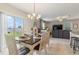 An open-concept dining room with a sliding glass door and an elegant chandelier fixture at 6180 Spring Crayfish Ave, New Port Richey, FL 34653