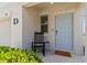 Inviting front porch with a light blue door, black rocking chair and lush greenery at 6180 Spring Crayfish Ave, New Port Richey, FL 34653