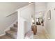 A hallway with carpet, a staircase, with a view of a living room at the end of the hall at 6180 Spring Crayfish Ave, New Port Richey, FL 34653