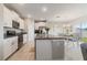 Modern kitchen features white cabinets, stainless appliances, a kitchen island, and an adjacent dining area at 6180 Spring Crayfish Ave, New Port Richey, FL 34653