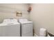 This functional laundry room features modern appliances and overhead shelving for storage at 6180 Spring Crayfish Ave, New Port Richey, FL 34653