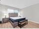 Bedroom featuring light colored walls, bench and queen bed with gray headboard at 6400 46Th N Ave # 203, Kenneth City, FL 33709