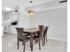 Dining area with a wooden table set near a kitchen with white cabinets at 6400 46Th N Ave # 203, Kenneth City, FL 33709