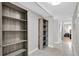 Hallway with shelving nook leads into a bedroom with nightstand, lamp, and window at 6400 46Th N Ave # 203, Kenneth City, FL 33709