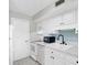 Modern kitchen with white cabinets, blue backsplash, updated appliances, and efficient layout at 6400 46Th N Ave # 203, Kenneth City, FL 33709