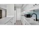 Well-lit kitchen featuring white cabinets, blue backsplash, and tile flooring at 6400 46Th N Ave # 203, Kenneth City, FL 33709