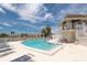 Community pool with lifeguard station, lounge chairs, and beautiful view of neighboring buildings and clear sky at 6400 46Th N Ave # 203, Kenneth City, FL 33709