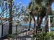 Backyard view featuring a black metal fence and distant water views with boat, accented by lush greenery at 6407 1St Palm Pt, St Pete Beach, FL 33706