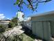 Backyard showcasing a brick patio, small garden, and serene tropical view with a high-rise in the background at 6407 1St Palm Pt, St Pete Beach, FL 33706