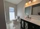 Bathroom features a marble vanity, three-light fixture, and toilet next to the shower enclosure at 6407 1St Palm Pt, St Pete Beach, FL 33706