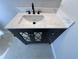 Bathroom vanity featuring marble countertop, a vessel sink, matte black faucet, and decorative mirrored doors at 6407 1St Palm Pt, St Pete Beach, FL 33706