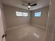 Bedroom featuring two windows, neutral walls, and a ceiling fan, creating a bright and comfortable space at 6407 1St Palm Pt, St Pete Beach, FL 33706