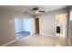View of bedroom leading to bathroom and room with hardwood-style floors and ceiling fan at 6407 1St Palm Pt, St Pete Beach, FL 33706