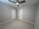 Bedroom with neutral carpet, ceiling fan, closet, and white doors for a clean, comfortable space at 6407 1St Palm Pt, St Pete Beach, FL 33706