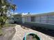 Charming home featuring a quaint brick walkway, complemented by lush greenery and palm trees at 6407 1St Palm Pt, St Pete Beach, FL 33706