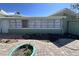 Rear exterior view with brick patio and rows of windows, perfect for natural light and outdoor enjoyment at 6407 1St Palm Pt, St Pete Beach, FL 33706