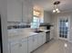 A clean, white kitchen showcases updated appliances, stylish lighting, and functional cabinet space at 6407 1St Palm Pt, St Pete Beach, FL 33706