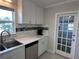 An airy kitchen featuring white cabinetry, stainless steel appliances, and a stylish backsplash design at 6407 1St Palm Pt, St Pete Beach, FL 33706