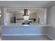 A modern, white kitchen features stainless steel appliances, a breakfast bar, and a stylish range hood at 6407 1St Palm Pt, St Pete Beach, FL 33706