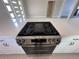 Stainless steel range with cooktop with view of white cabinets and countertops at 6407 1St Palm Pt, St Pete Beach, FL 33706