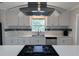 Bright kitchen showcasing white cabinets, stainless steel appliances, and a sleek range hood over the cooktop at 6407 1St Palm Pt, St Pete Beach, FL 33706