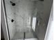 Modern shower enclosed with marble-like tile walls, a matte black shower head, and a glass enclosure at 6407 1St Palm Pt, St Pete Beach, FL 33706