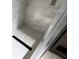View of inside of shower with marble-style walls, hexagon style floor, and rain style shower head at 6407 1St Palm Pt, St Pete Beach, FL 33706