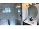 Angle view of shower with marble-style shower walls, glass door, and rain style shower head at 6407 1St Palm Pt, St Pete Beach, FL 33706