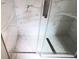 Angle view of inside of the shower with marble-style walls, glass door, and hexagon style floor at 6407 1St Palm Pt, St Pete Beach, FL 33706