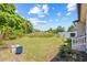 Spacious backyard featuring a lush lawn, mature trees, and a well-maintained fence line, perfect for outdoor activities at 6741 51St N Way, Pinellas Park, FL 33781