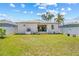 Backyard view of the home featuring a well-manicured lawn, covered patio, and fenced yard, offering privacy at 6741 51St N Way, Pinellas Park, FL 33781