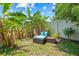 Backyard view of a tranquil seating area surrounded by lush tropical foliage, creating a private oasis at 6741 51St N Way, Pinellas Park, FL 33781