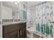 Bright bathroom featuring a vanity with granite countertop and a shower-tub combo with a decorative curtain at 6741 51St N Way, Pinellas Park, FL 33781