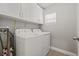 Laundry area with modern white washer and dryer, ample cabinet space, and a bright window for natural light at 6741 51St N Way, Pinellas Park, FL 33781