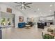Open-concept living room with a large ceiling fan, island kitchen, and bright, airy ambiance at 6741 51St N Way, Pinellas Park, FL 33781