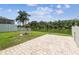 Backyard with a paved patio, fire pit, grassy area and white picket fence overlooking a lake at 7246 Bucks Ford Dr, Riverview, FL 33578