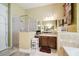 Bright bathroom featuring a walk-in shower, vanity with dark wood cabinets, and neutral tile flooring at 7246 Bucks Ford Dr, Riverview, FL 33578