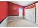 Bedroom with red and gray walls, carpet flooring, and a closet with white bi-fold doors at 7246 Bucks Ford Dr, Riverview, FL 33578