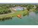 Aerial view of a wooden pier extending into a lake, surrounded by lush greenery at 7246 Bucks Ford Dr, Riverview, FL 33578