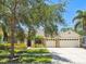 Charming single-Gathering home boasting a three car garage, stone accents and lush landscaping at 7246 Bucks Ford Dr, Riverview, FL 33578