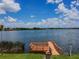 Scenic view of a tranquil lake from the wooden pier, with clear skies and distant homes at 7246 Bucks Ford Dr, Riverview, FL 33578