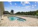 Backyard with a brick-lined pool, and a white picket fence overlooking a lake and palm trees at 7246 Bucks Ford Dr, Riverview, FL 33578