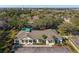Aerial view of community clubhouse with green roof, parking, landscaping and surrounding trees at 7703 N Branch Ave, Tampa, FL 33604