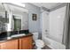Well-lit bathroom featuring a vanity with dark countertop and combined tub and shower with gray and white tile at 7703 N Branch Ave, Tampa, FL 33604