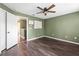 Bedroom with ceiling fan, laminate floors and view of the hallway at 7703 N Branch Ave, Tampa, FL 33604