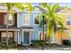 Charming blue townhome with tropical landscaping and a welcoming front entrance at 7703 N Branch Ave, Tampa, FL 33604