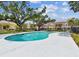 Community swimming pool with lounge chairs surrounded by trees and townhome units in the background at 7703 N Branch Ave, Tampa, FL 33604