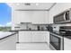 Modern kitchen with stainless steel appliances, a marble backsplash, and a large countertop overlooking the city at 777 N Ashley Dr # 1506, Tampa, FL 33602
